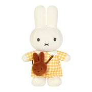 A white plush bunny doll wearing a yellow and white gingham dress, holding a small brown bunny-shaped backpack, shown against a plain white background.