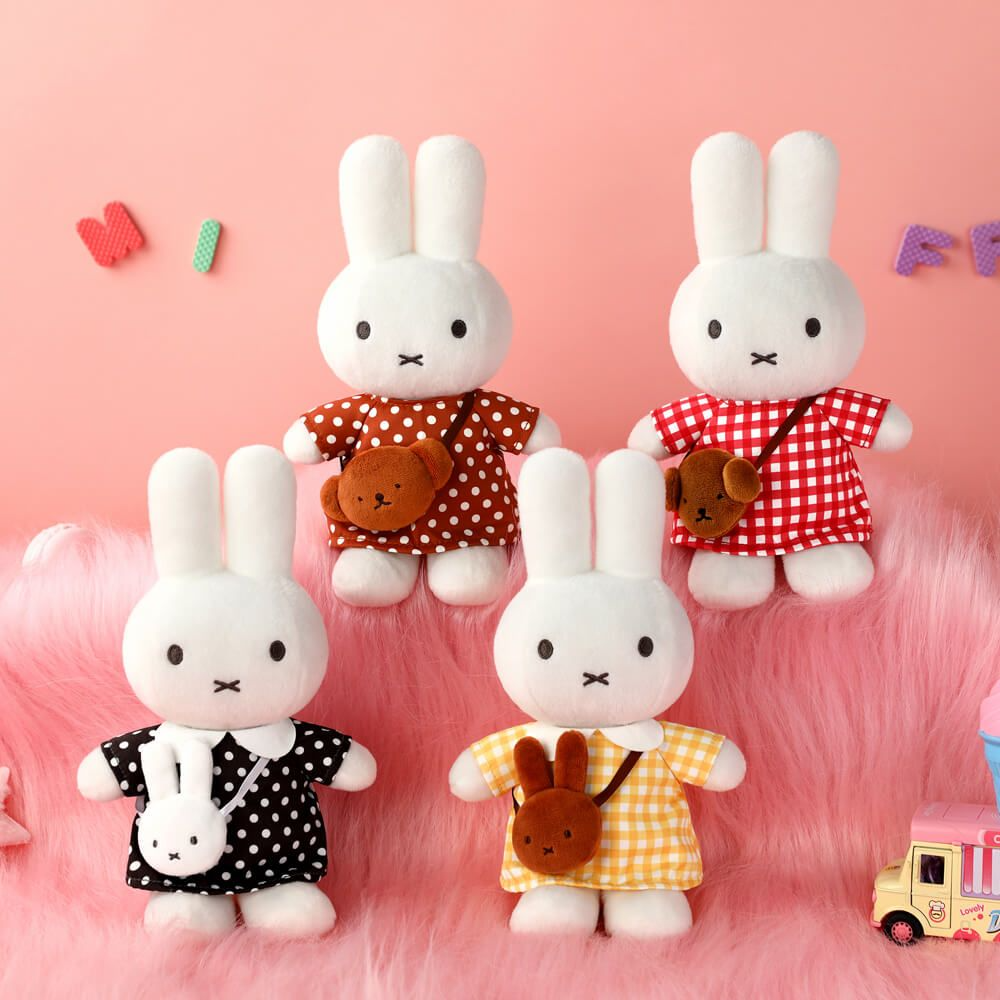 Four white rabbit plush toys in various outfits on a pink background