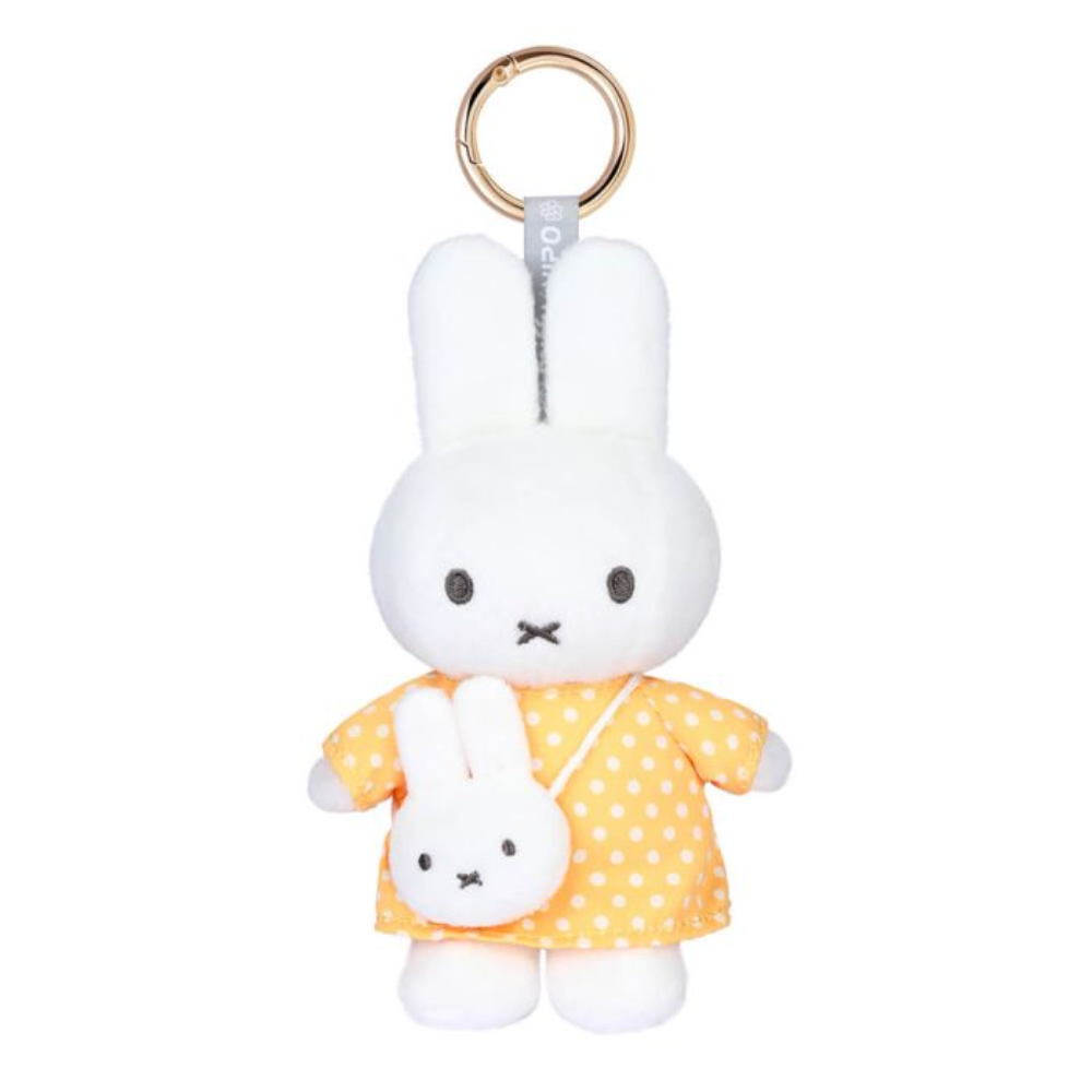 A plush keychain featuring a white bunny character wearing a yellow dress with white polka dots, holding a small matching white bunny crossbody bag, with a gold-tone key ring at the top.