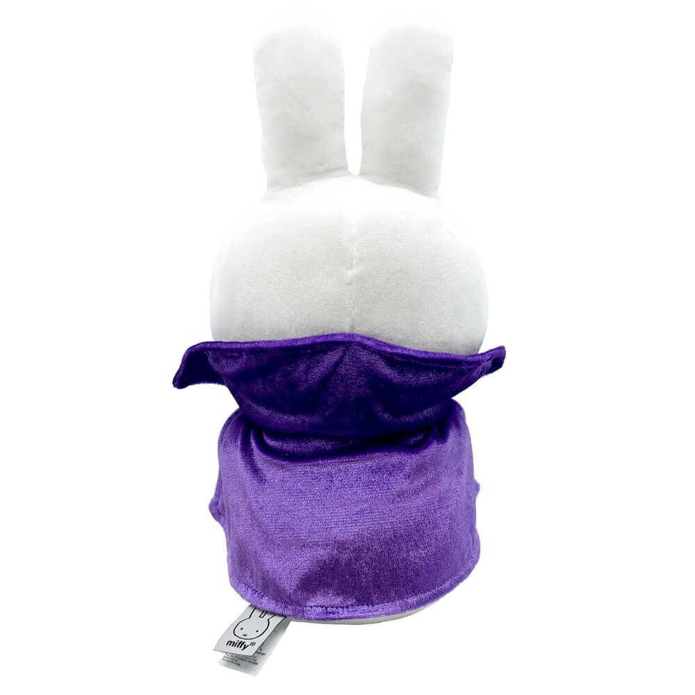 A white plush bunny head with long upright ears wearing a purple neck warmer or balaclava-style hood, shown against a plain white background. A small sewn tag is visible near the bottom of the purple fabric.