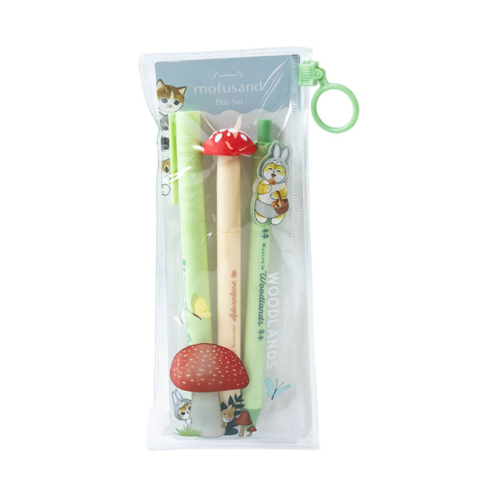 A clear zippered pencil pouch with a green hanging loop, containing a woodland-themed pen set. The set includes a green pen, a beige pen with a red mushroom cap topper, and a green pencil with a rabbit illustration, all decorated with forest motifs like mushrooms, trees, and animals.