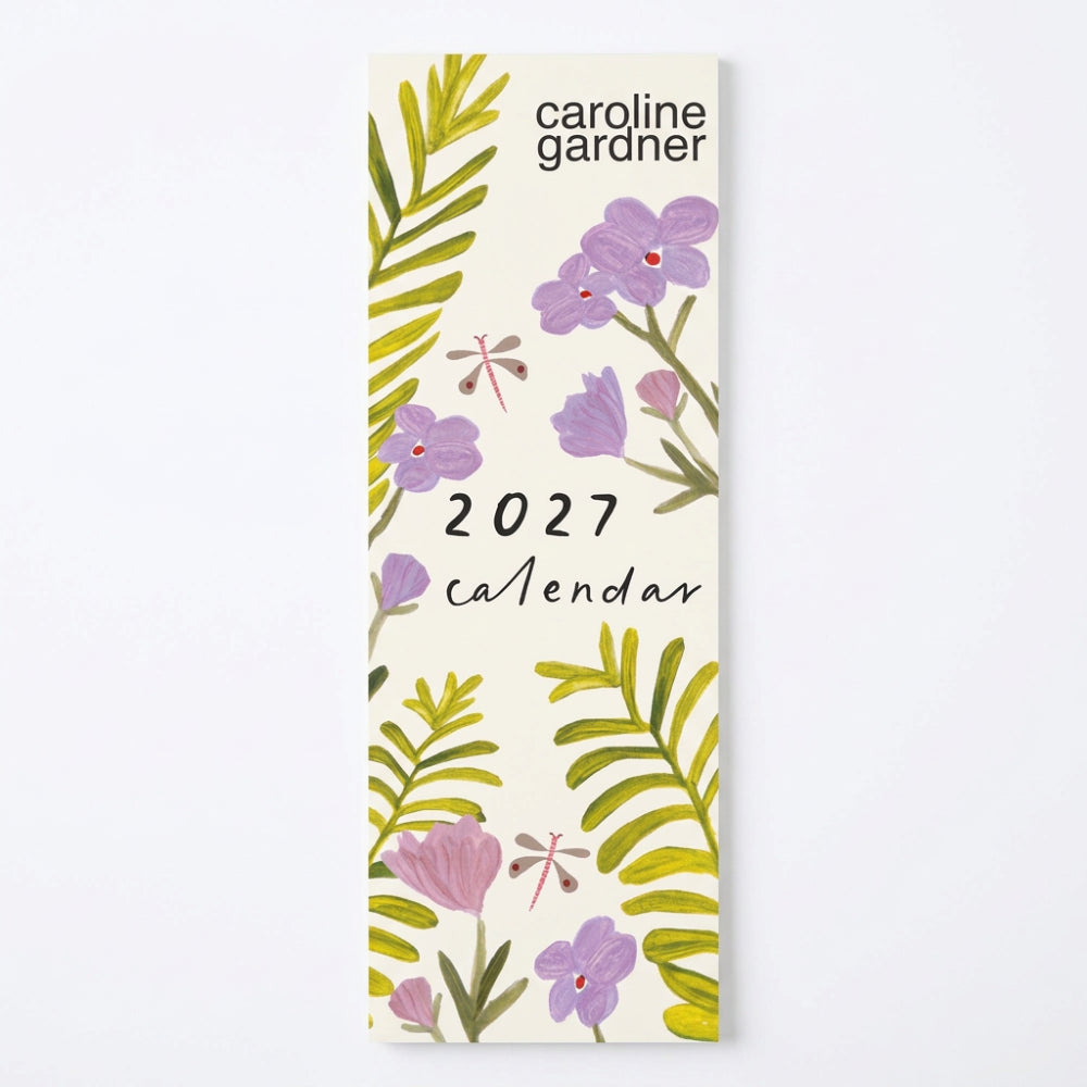 A 2027 wall calendar cover by Caroline Gardner featuring a botanical design with purple flowers, green palm leaves, and dragonflies on a cream background.
