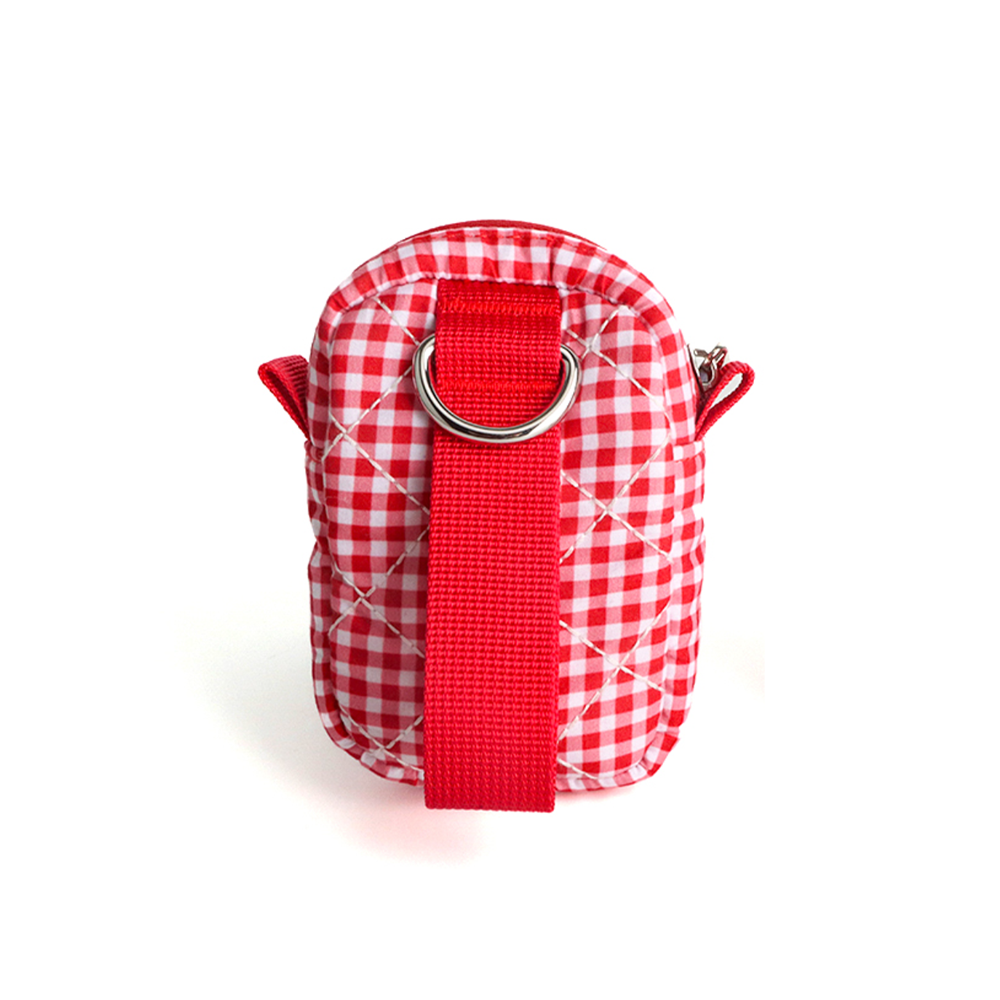 A small quilted crossbody bag with a red and white gingham pattern, featuring a prominent red webbing strap with a silver metal D-ring, set against a plain white background.
