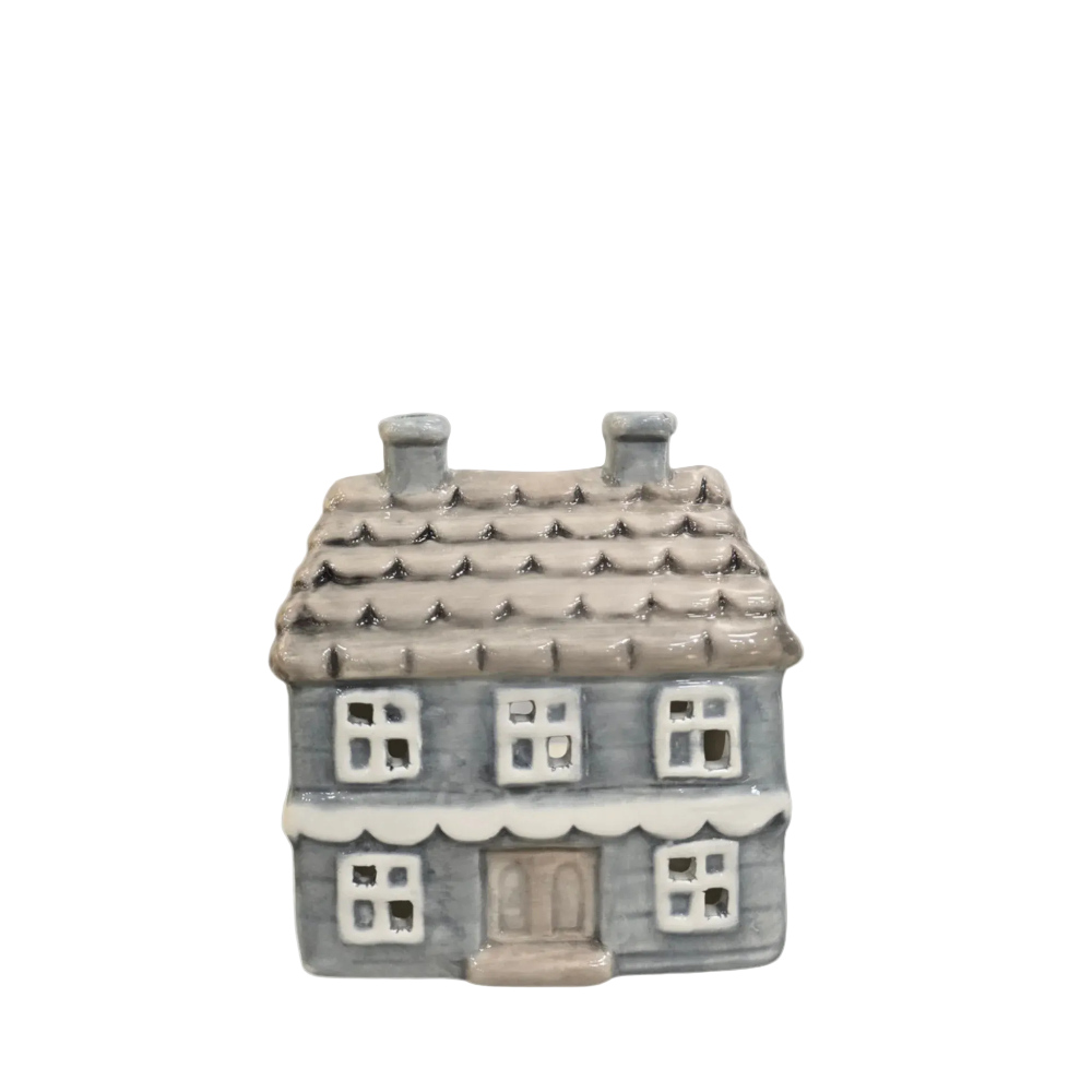 A small ceramic house-shaped container or ornament with a gray-blue body, brown roof, white window frames, and a beige door, shown on a plain light gray background.