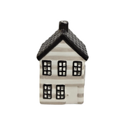A small ceramic house-shaped candle holder or decorative figurine with a white body, black roof, and black window details, shown against a plain light gray background.