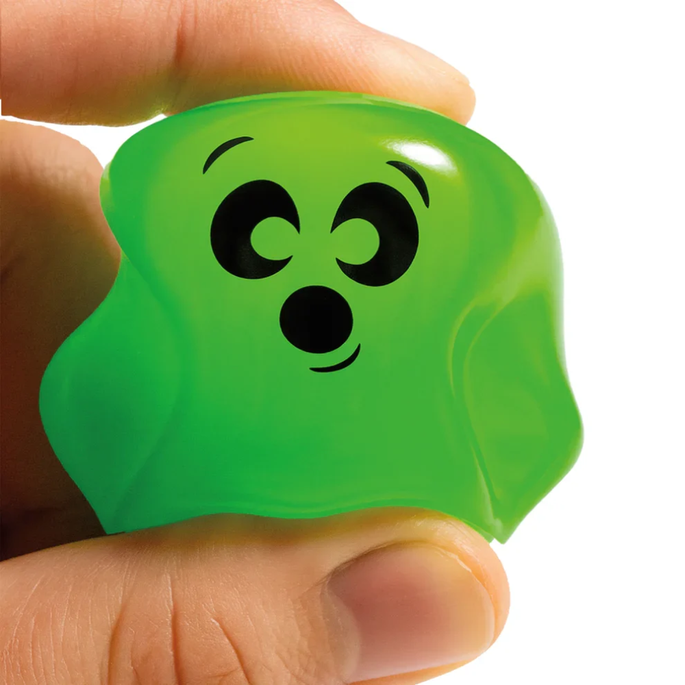 Green stress ball with a face design held in a hand against a white background