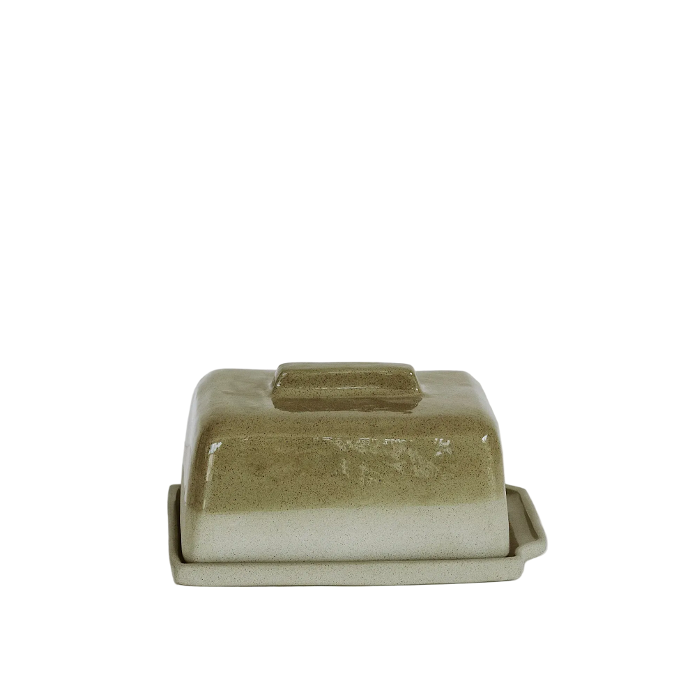 A rectangular ceramic butter dish with a matching lid, featuring a speckled sage green and white glaze, set against a plain white background.