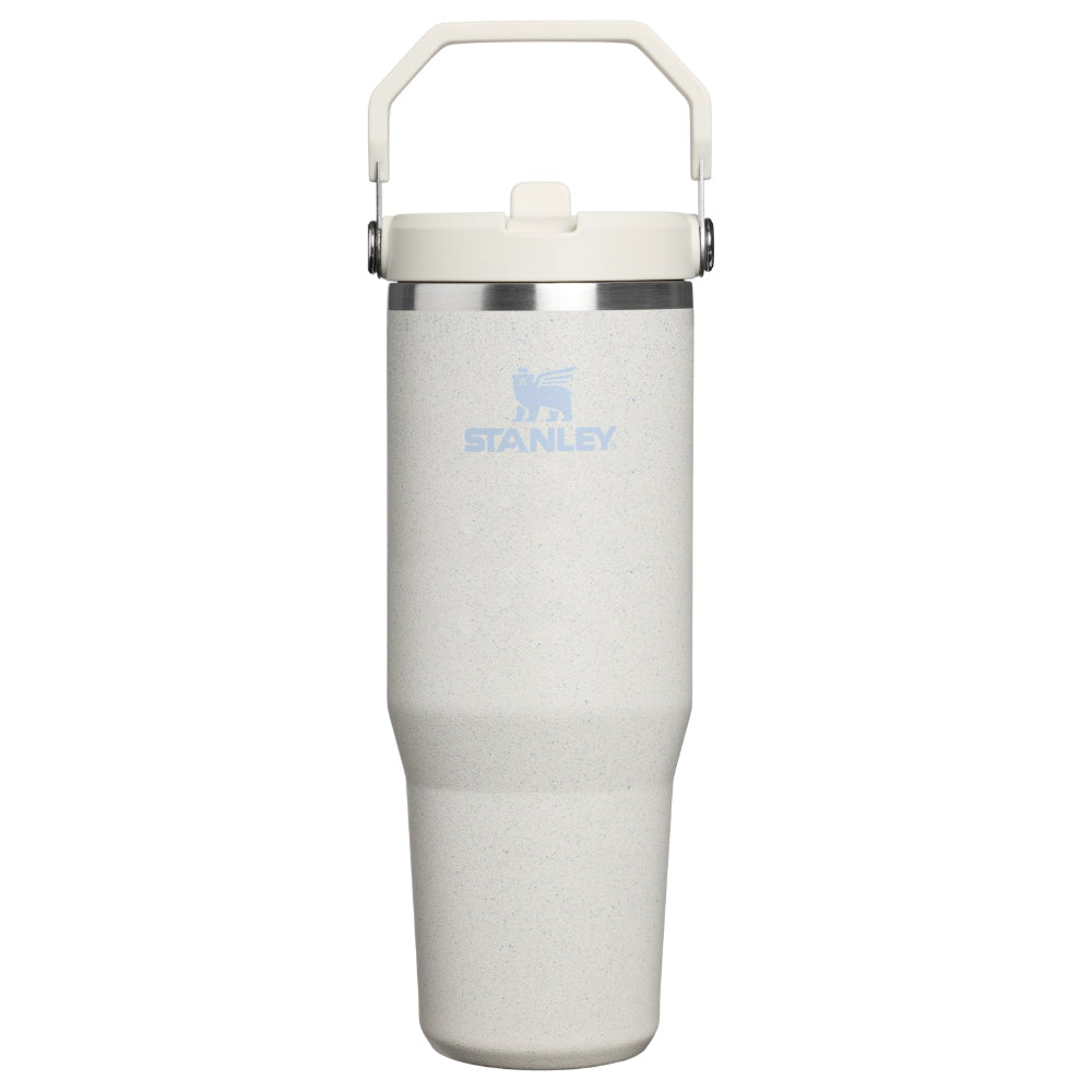 A Stanley vacuum-insulated tumbler in a light speckled off-white finish, featuring a matching off-white lid with a carrying handle and a light blue printed Stanley logo on the front.
