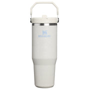 A Stanley vacuum-insulated tumbler in a light speckled off-white finish, featuring a matching off-white lid with a carrying handle and a light blue printed Stanley logo on the front.
