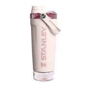 A light pink Stanley water bottle with a matching carry loop and a clear cap, shown on a solid light gray background.