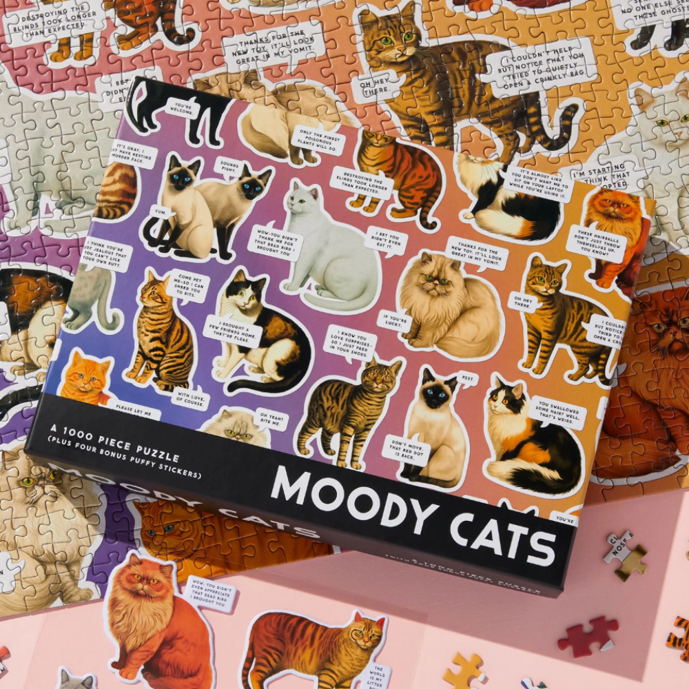 Jigsaw puzzle box for 'Moody Cats' puzzle with cat illustrations on a colorful background.