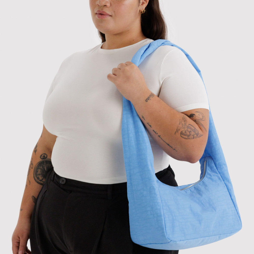 Person holding a blue bag against a white background