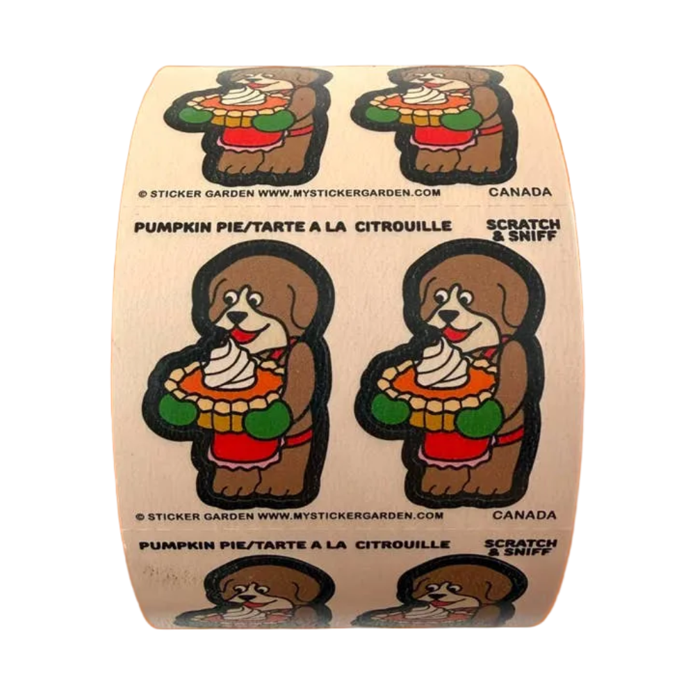 A roll of 'Scratch & Sniff' scented toilet paper stickers featuring a cartoon pumpkin pie dog, shown against a solid orange background.