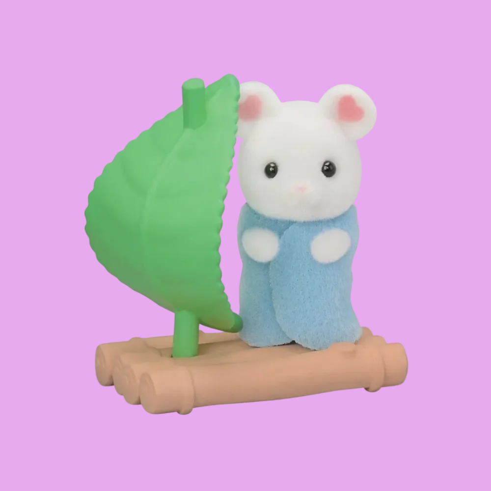 A small plush toy animal character with a white body, pink inner ears, black eyes, and a blue outfit, standing beside a green leaf-shaped sail on a tan base against a plain white background.