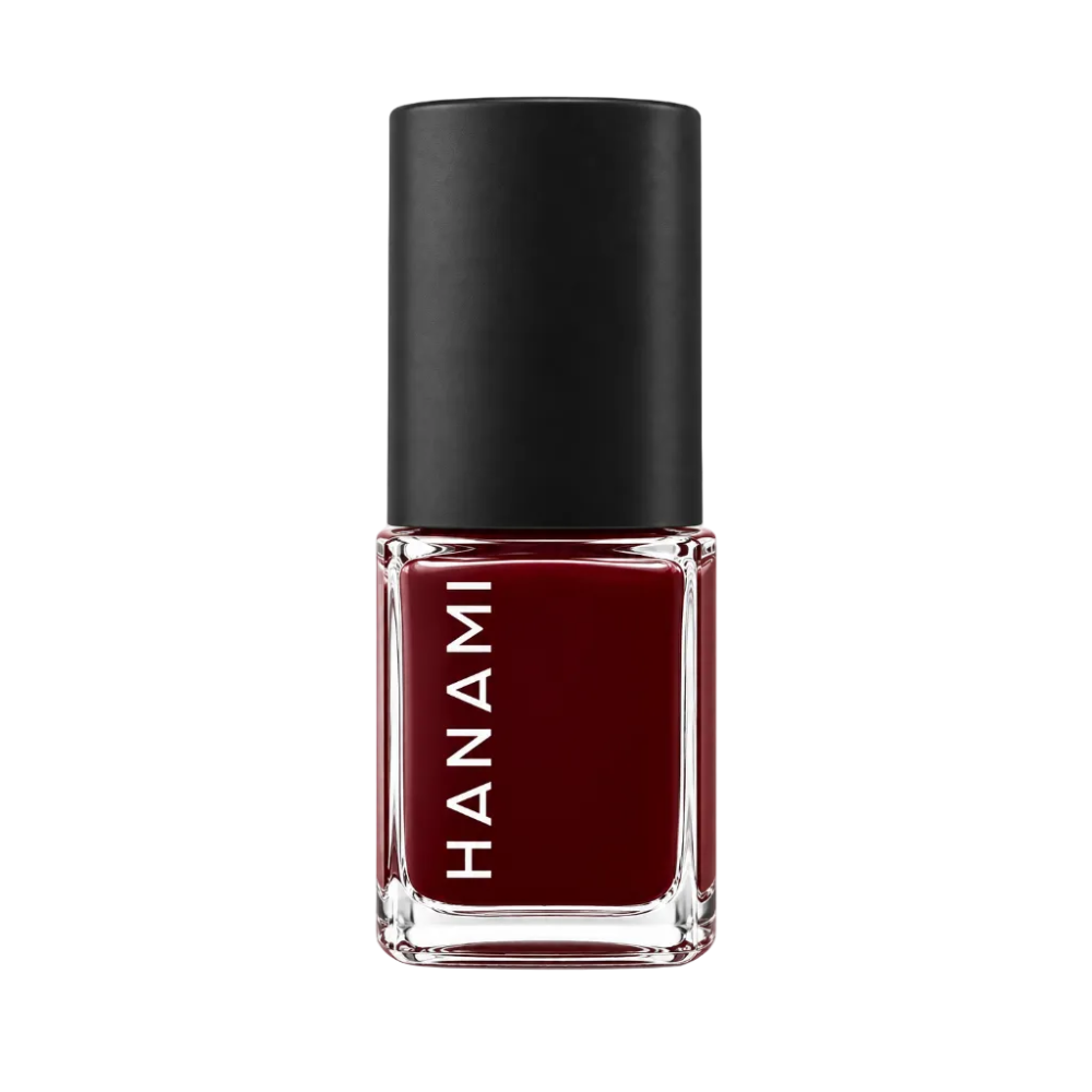 A bottle of Hanami nail polish in a deep burgundy red shade, featuring a black cap and a clear glass base with the brand name 'HANAMI' printed vertically in white.