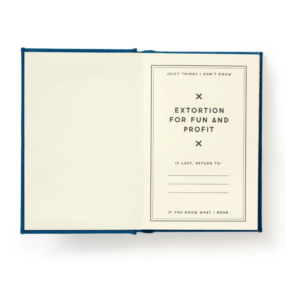 An open notebook or journal with cream-colored pages and a dark blue cover, photographed from above on a white background. The right page contains printed text including the title 'EXTORTION FOR FUN AND PROFIT' and return information.