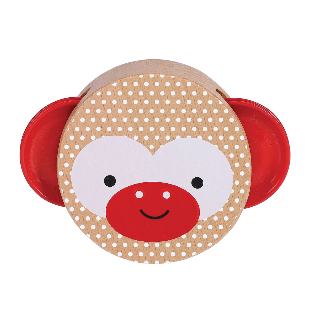 A wooden monkey toy with a round tan face covered in white polka dots, a white face area, a red snout, black eyes, and red side ears on a white background.