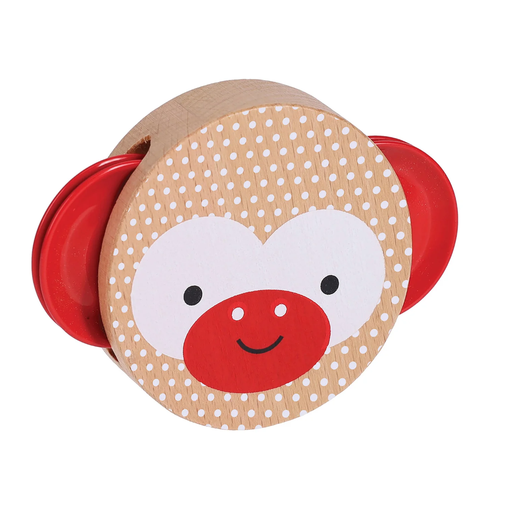 A wooden monkey-shaped toy rattle with a light brown wood grain body, white polka dots, a white face area, a red snout, and red side ears, shown on a plain white background.