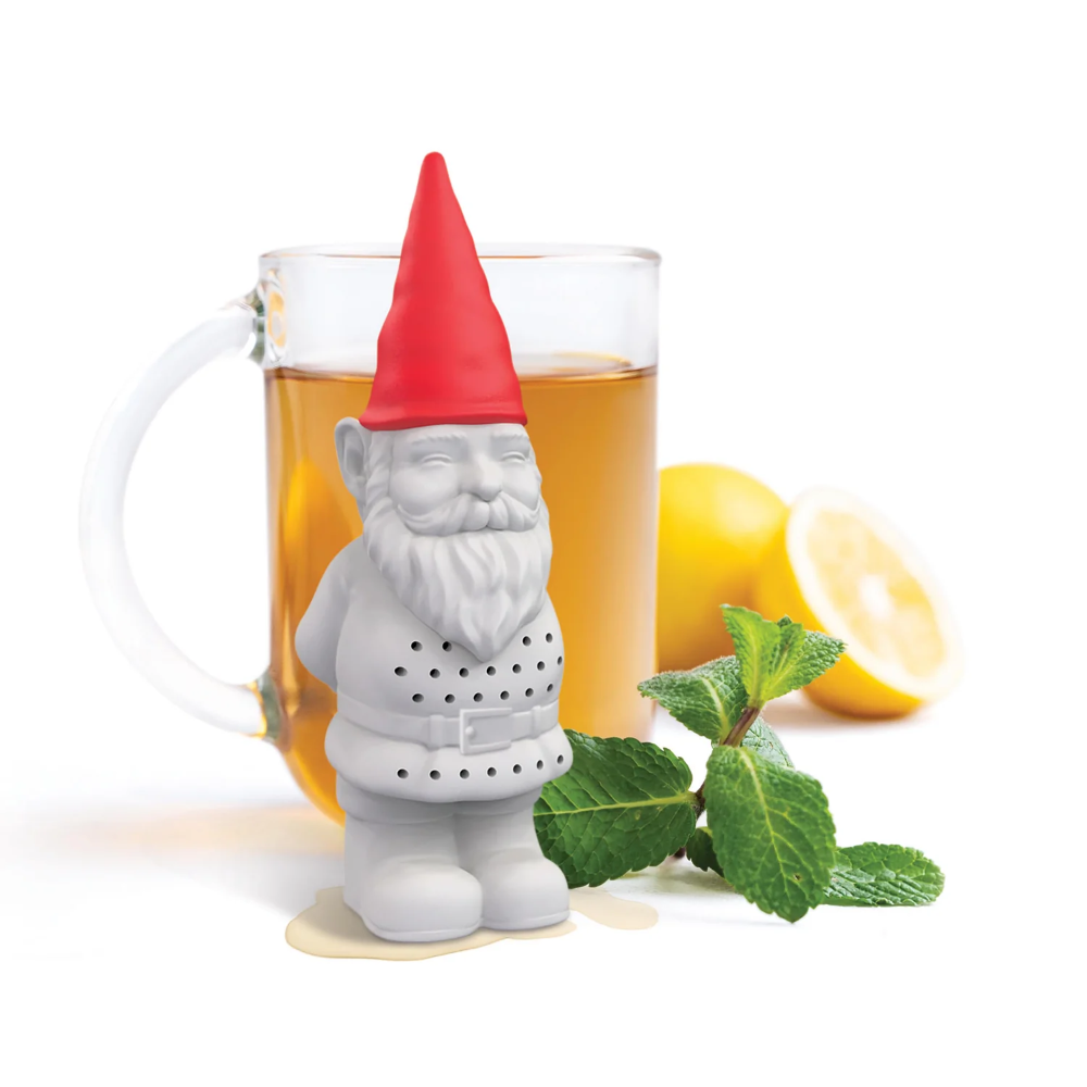 Gnome-shaped tea infuser with a glass of tea and lemon slices on a white background