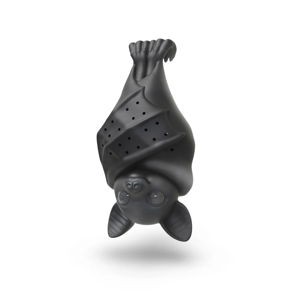A matte black silicone bath sponge shaped like an upside-down bat, floating against a clean white background with a soft shadow underneath.