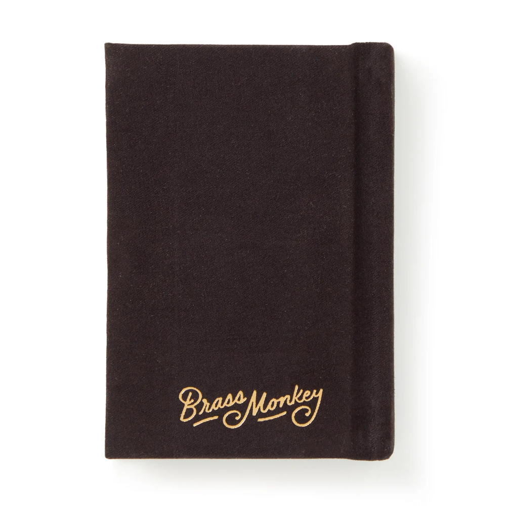 A dark brown fabric-covered notebook or journal with 'Brass Monkey' embroidered in gold cursive script near the bottom, shown on a clean white background.