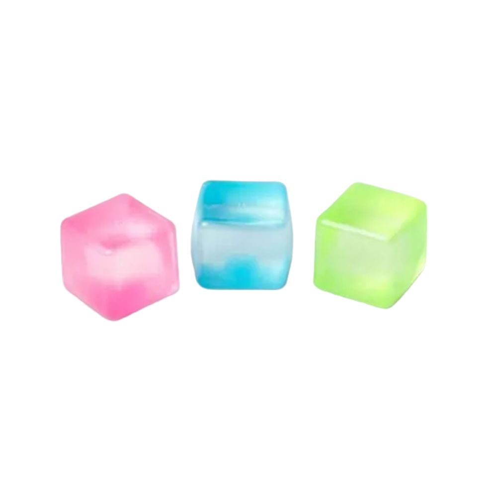 Three translucent cube-shaped ice cube molds in pink, blue, and green, arranged side by side on a plain white background.