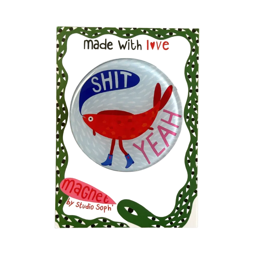A circular pinback magnet on its backing card. The magnet features a red cartoon fish with blue legs and feet on a light blue-gray background, with the words 'SHIT' in blue and 'YEAH' in pink.