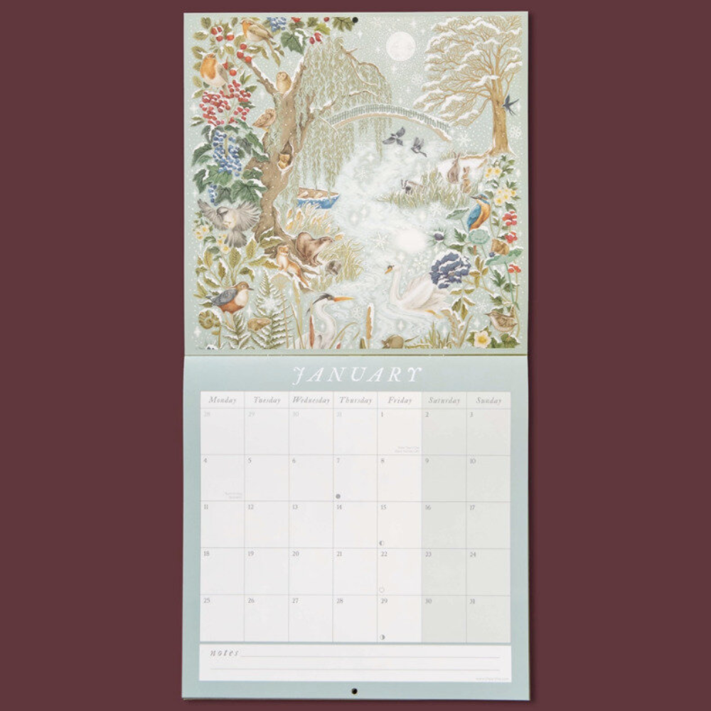 A hanging monthly calendar page with a detailed illustrated winter woodland cover and a January grid below, shown against a solid dark burgundy background.