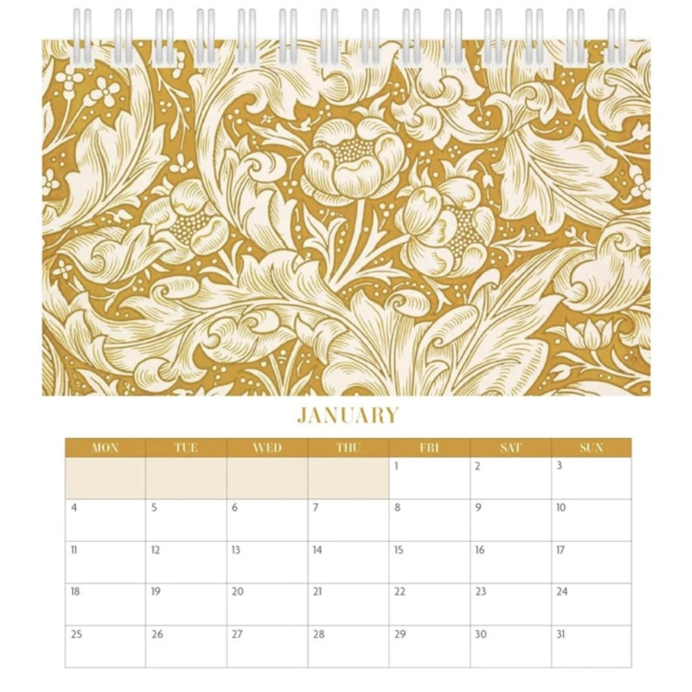 A spiral-bound desk calendar page with a gold and cream floral damask pattern across the top and a January calendar grid below on a white background.