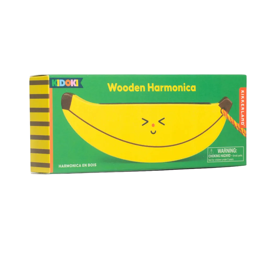A boxed children's toy labeled 'Wooden Harmonica' by Kidoki, shown on a clean white background. The package is predominantly green with a large yellow banana illustration and striped yellow-and-brown side panels.
