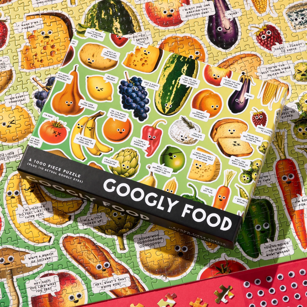 Jigsaw puzzle with cartoon food characters and a box labeled 'Googly Food' on a colorful background.