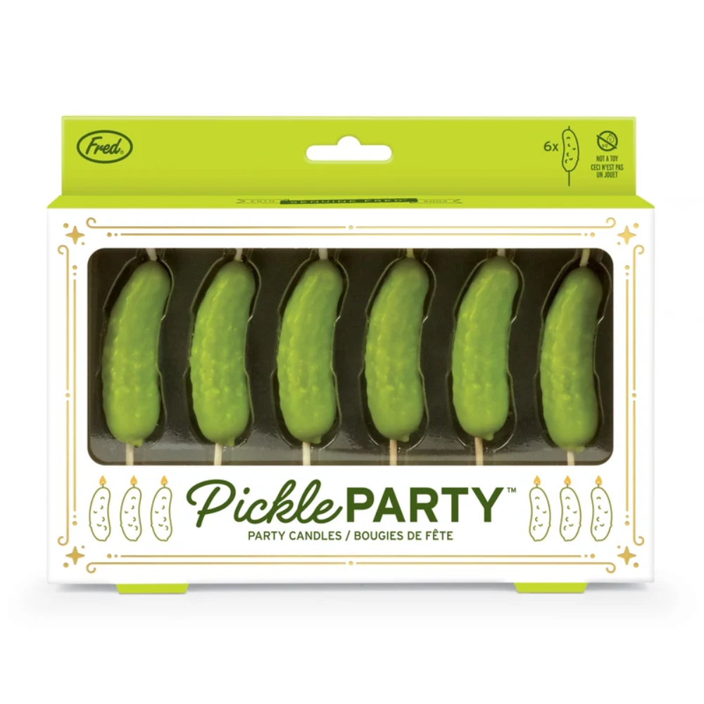 A package of six pickle-shaped party candles in a white box with a bright green header. The candles are shaped like green pickles on wooden skewers and are visible through a clear window on the front of the packaging.