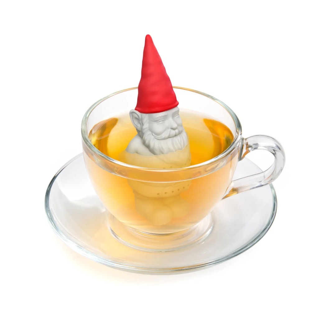 Tea infuser shaped like a gnome in a glass teacup with tea.